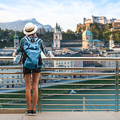 Städtereisende betrachtet Salzburgs Altstadt und Sehenswürdigkeiten bei der Nutzung einer City Card.
